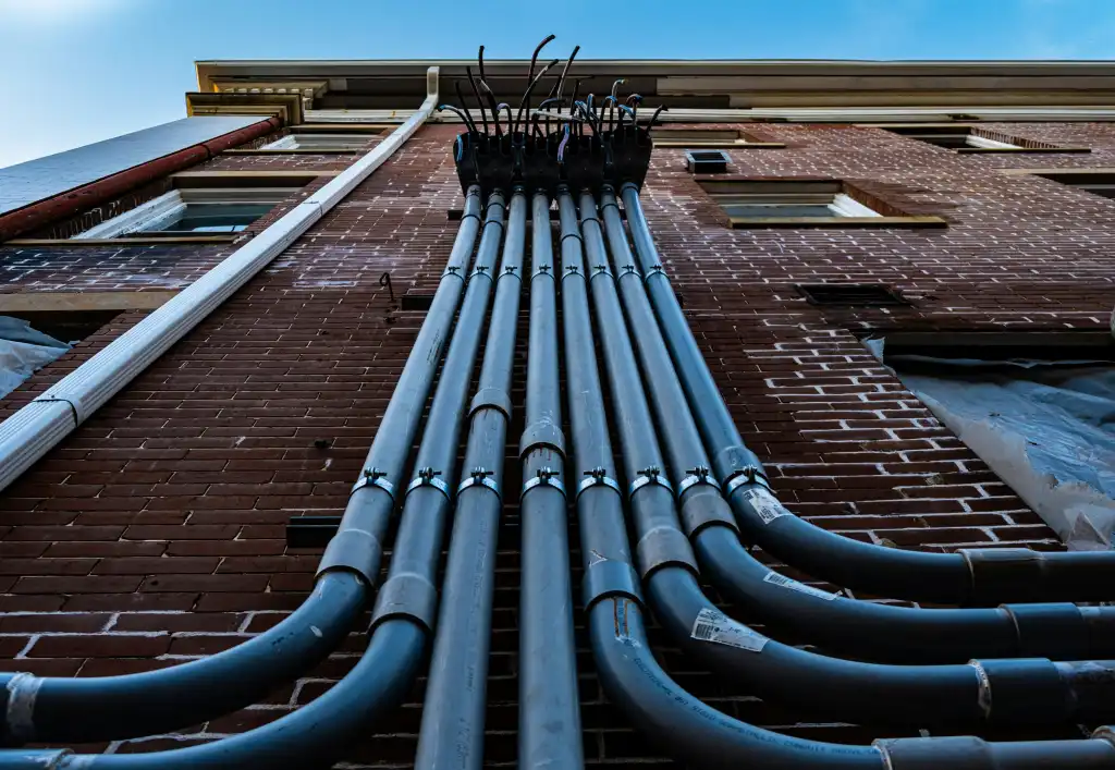 Electrical conduits running down the side of a building.