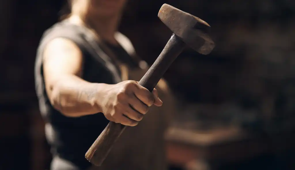 Woman, hand and holding hammer with small business for crafting metal and object at workshop. Female person, blacksmith and empowerment or affirmative action for welder work, welding and industrial