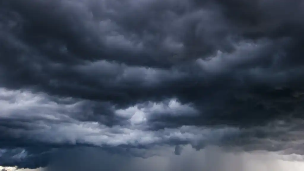 Dark sky with heavy clouds converging and a violent storm before the rain. Bad weather stormy weather moody weather ominous clouds.