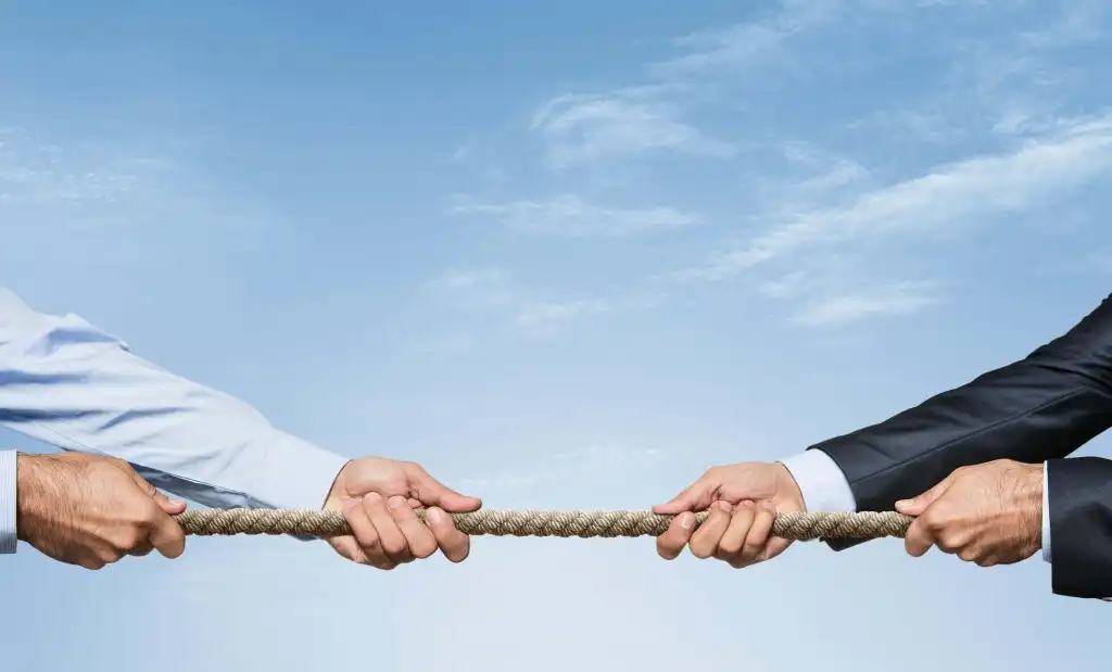 Tug war, two businessman pulling a rope in opposite directions isolated on white background