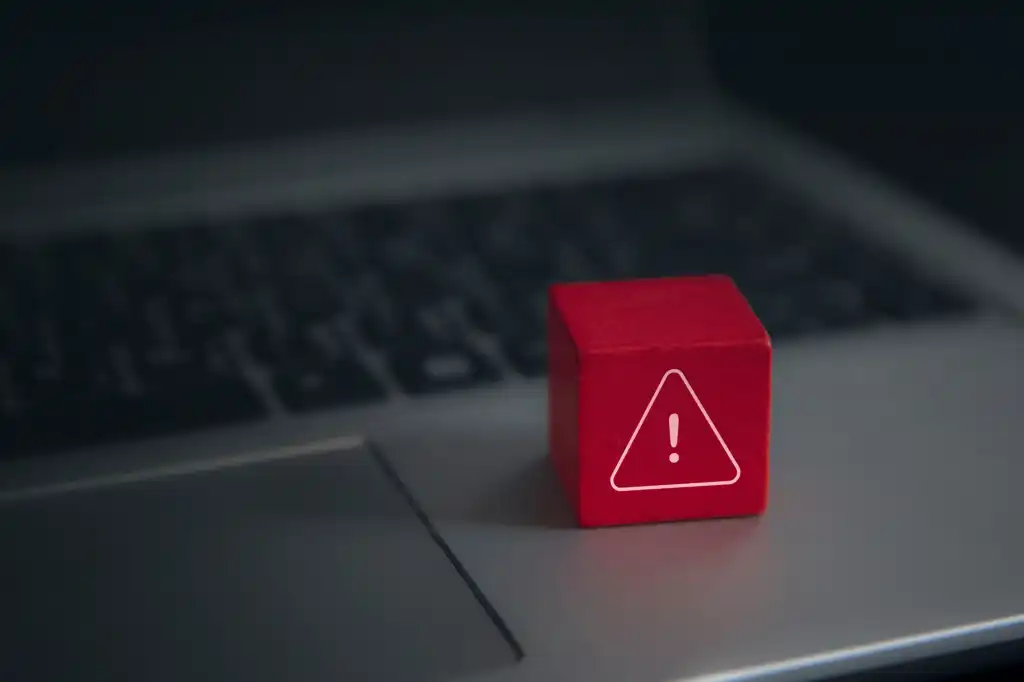 Red-warning-cube-on-a-laptop-keyboard Sicherheitslücke Alarm