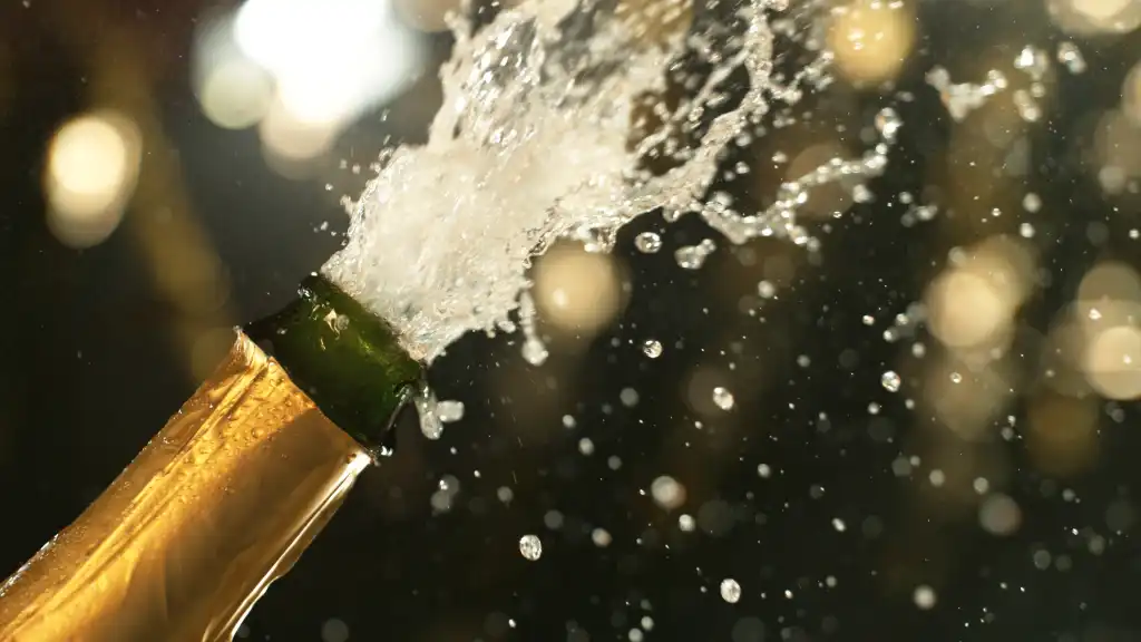Celebration theme with splashing champagne on black background.
